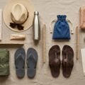 Shirdi packing checklist flat-lay with cotton clothes, umbrella, shawl, chappals and ID pouch